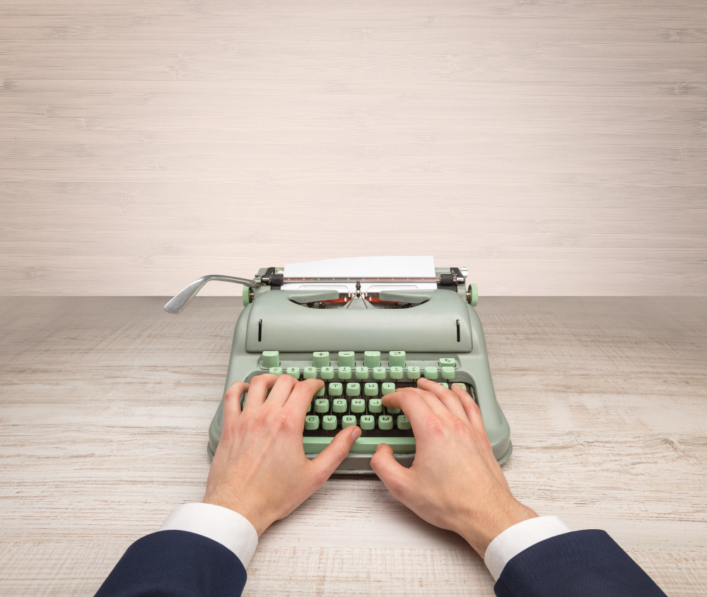 First person perspective elegant hand writing on an oldschool typewriter with copyspace